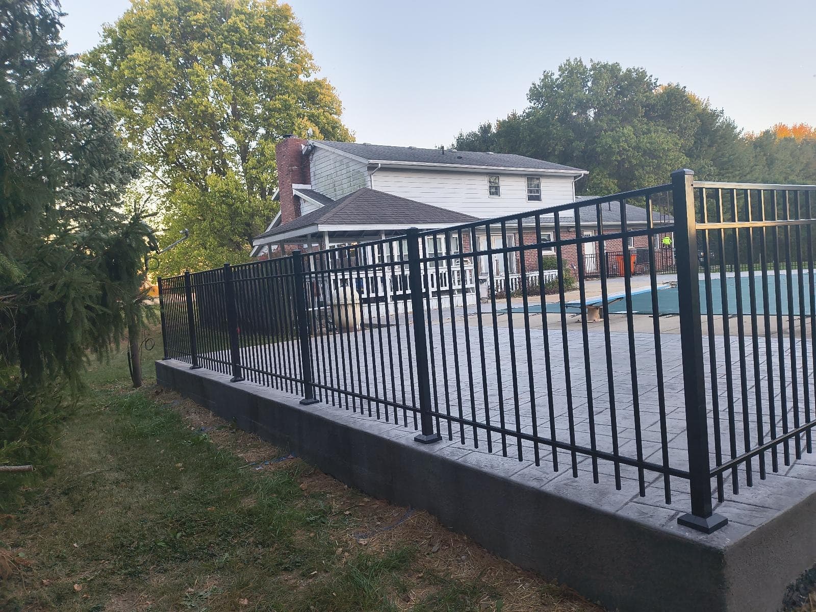 Black aluminum panels follow the edge of a raised paved area.