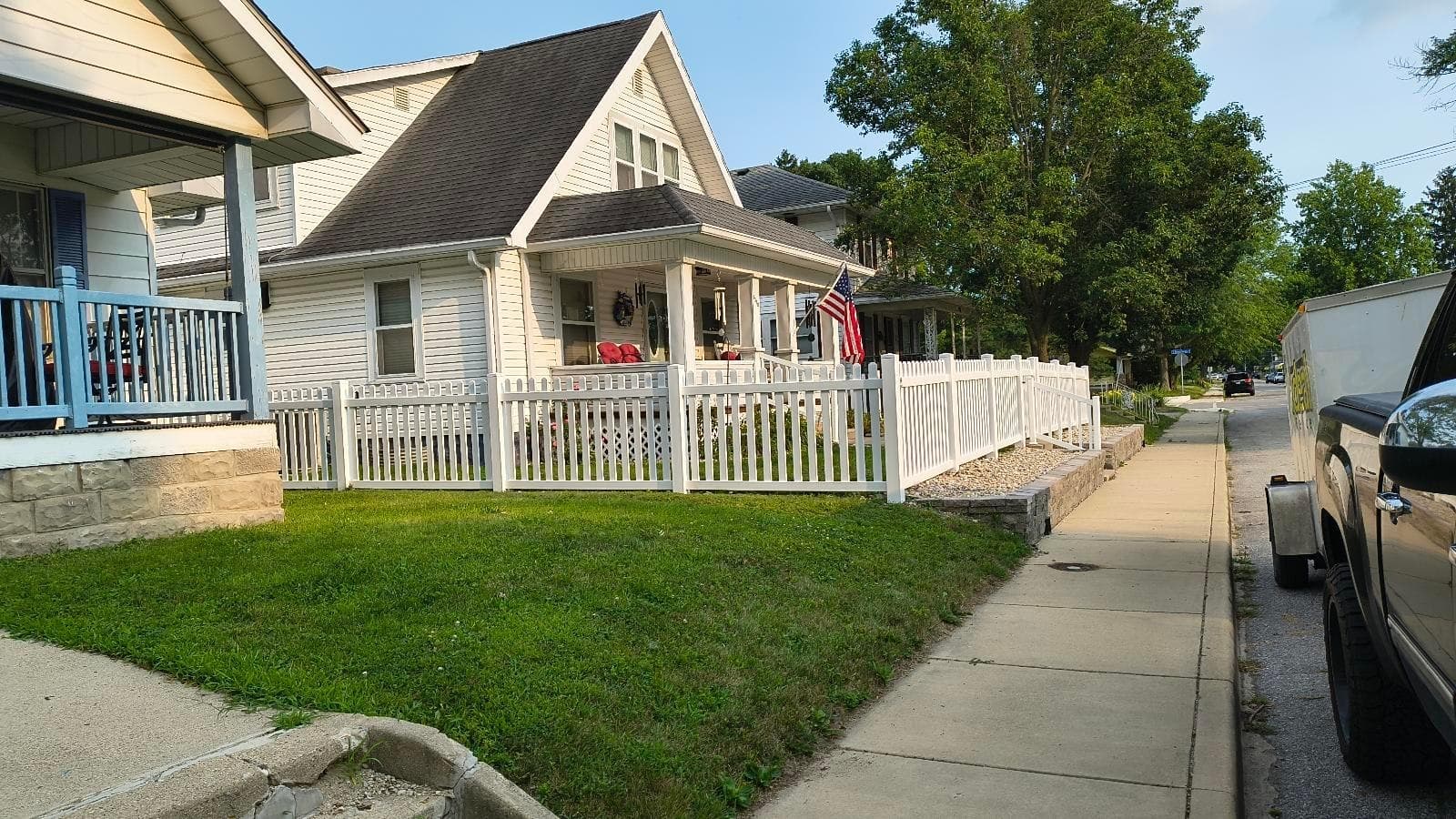 White picket fencing frames the lawn and front porch.