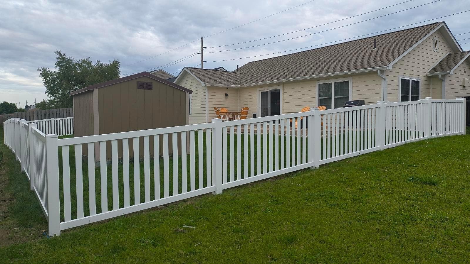 Open white pickets define the yard beside the house.