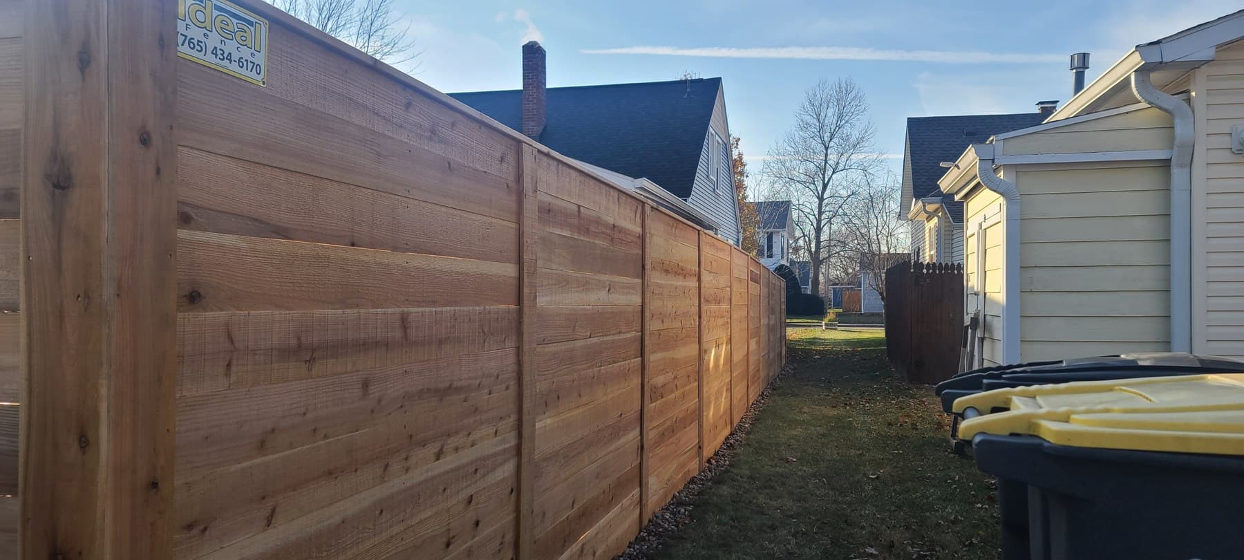 Wood boards create a boundary beside the narrow lawn next to the house.