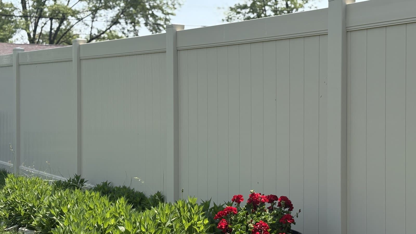 Gray vinyl privacy fence beside a flower bed in Noblesville, IN